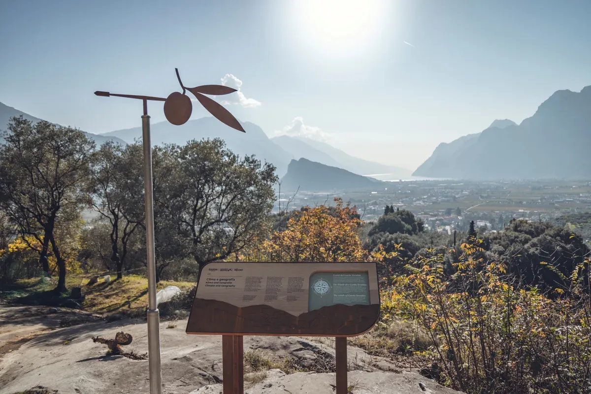 Olivenzweig-Skulptur und Infotafel am Olivenweg oberhalb von Arco mit Blick zum Gardasee