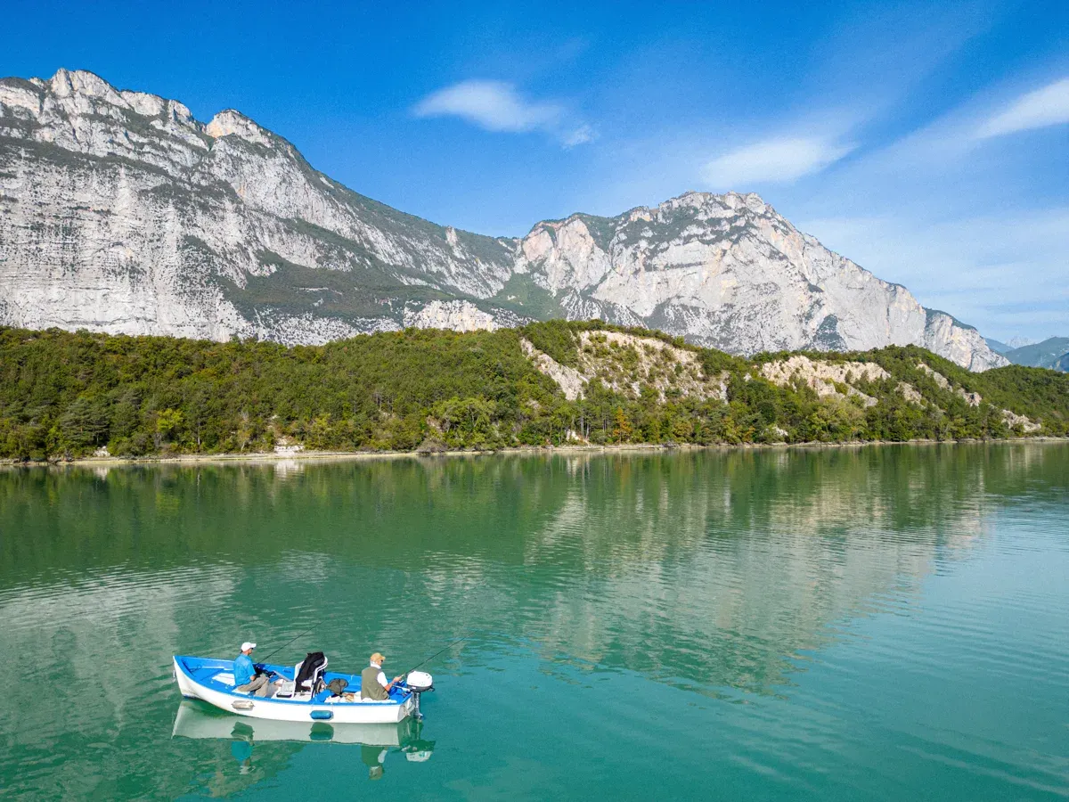 Zwei Angler im Boot auf dem Lago di Cavedine unter dem Monte Casale